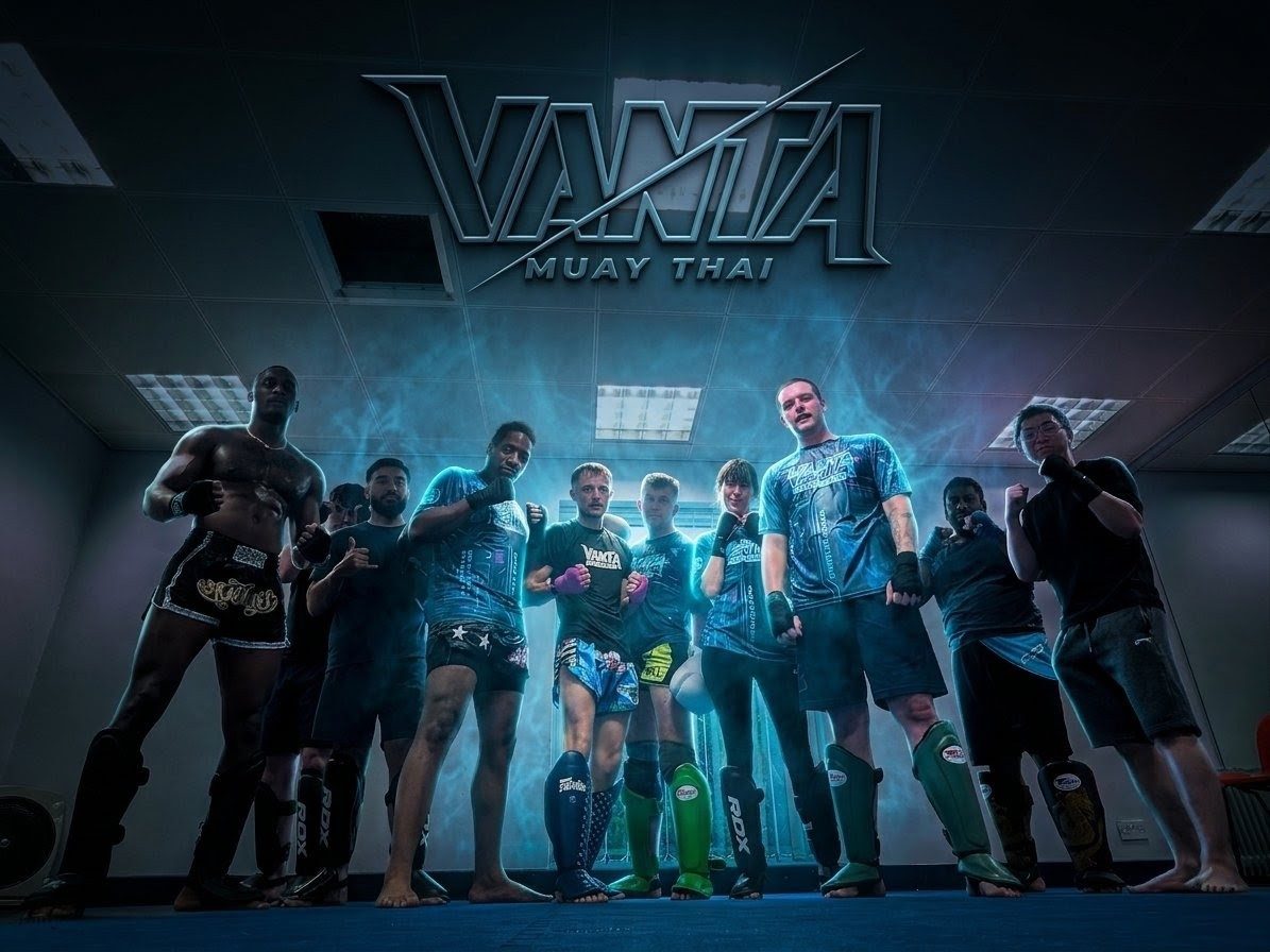The Vanta team in fight stance under the Vanta Muay Thai sign