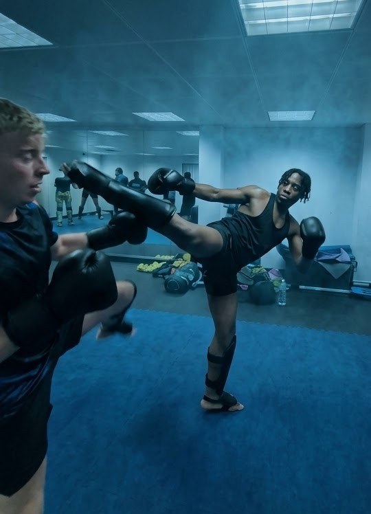 A Vanta member throwing a high roundhouse kick onto pads