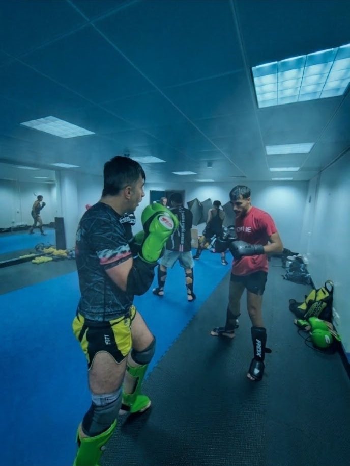 Pad work in the blue-lit training room
