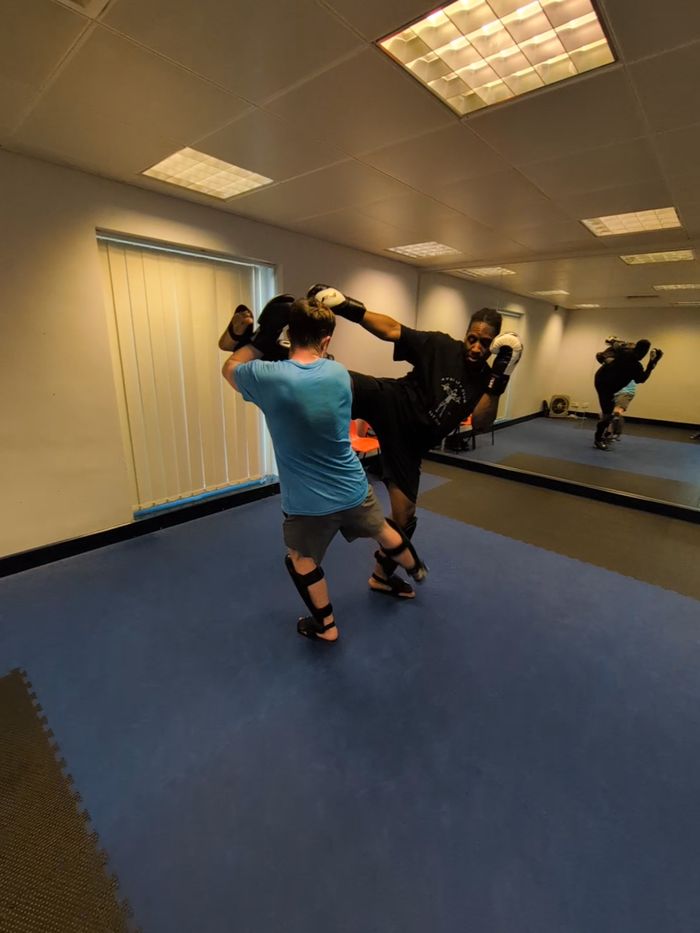 High kick onto a pad in front of the mirrors