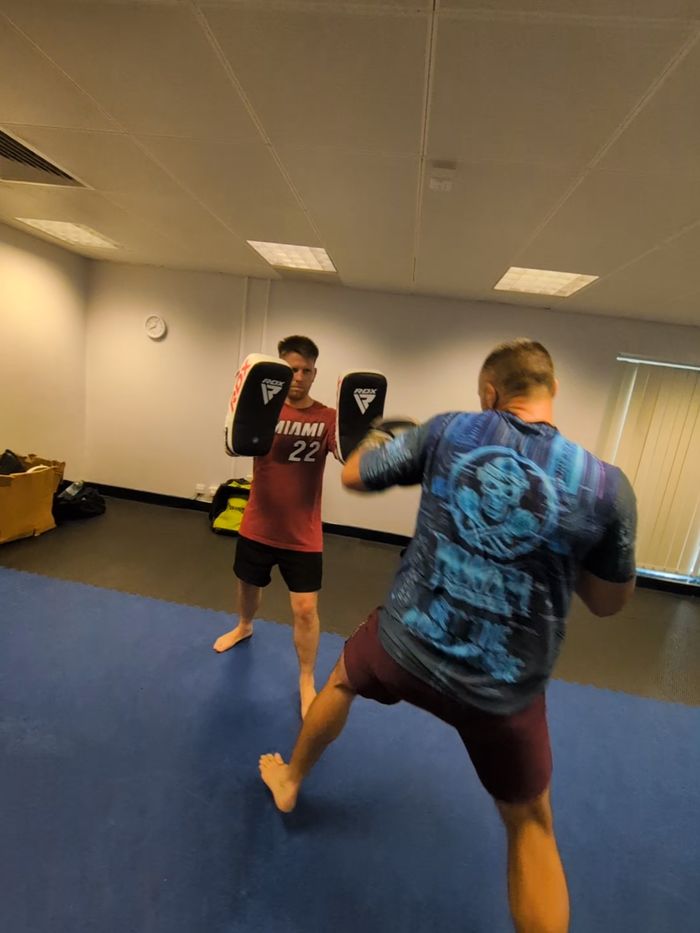 Member in a Vanta Tech T striking thai pads