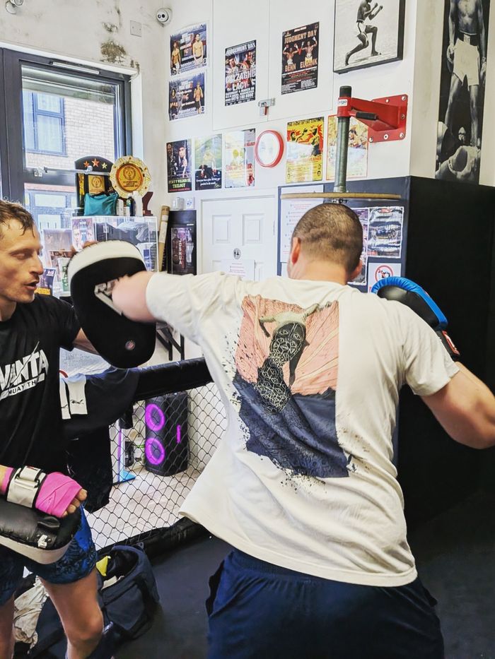 One-to-one pad work in a boxing gym
